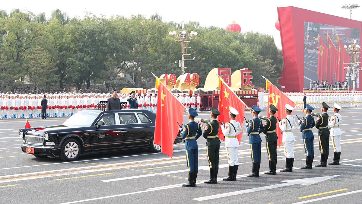 習(xí)近平驅(qū)車行進(jìn)至黨旗、國旗、軍旗前，向旗幟行注目禮